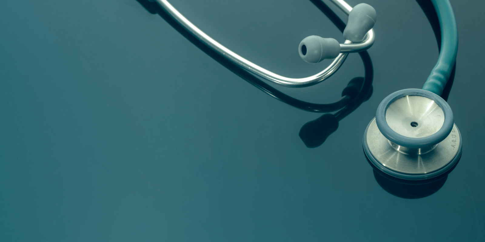 Stethoskop auf grünem Hintergrund als Symbol für den Gesundheitsbereich